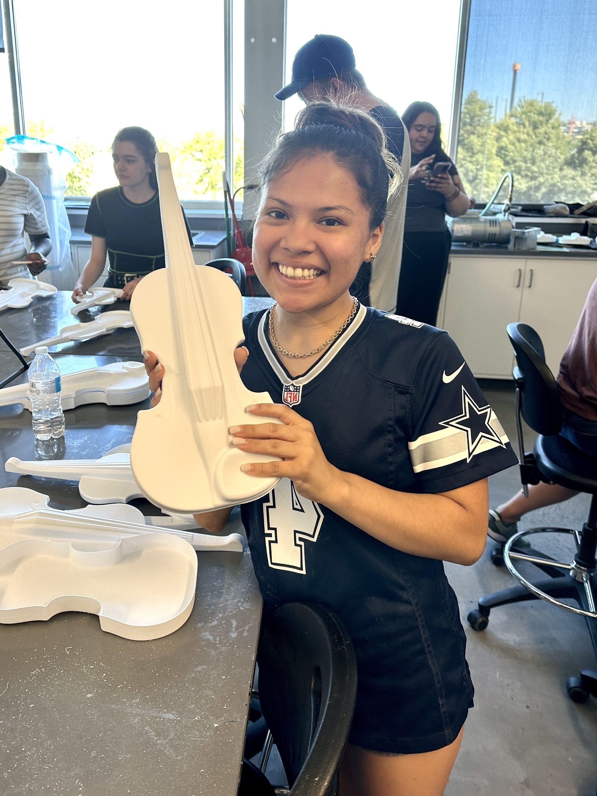 Student holding 3D printed violin