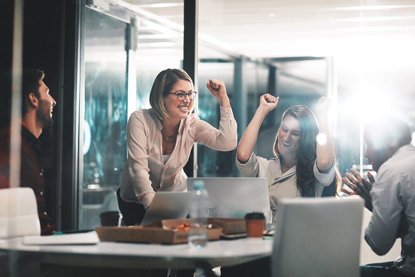 Shot of colleagues celebrating during a meeting in a modern office